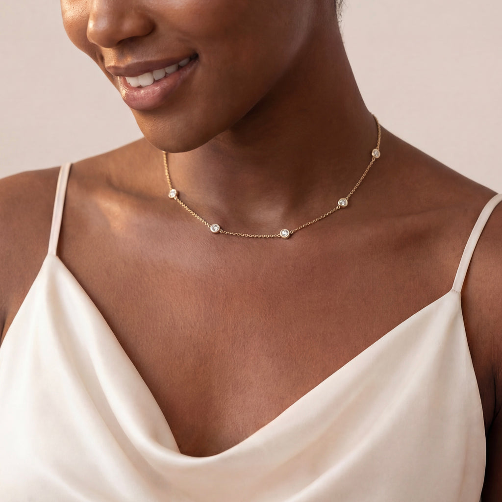 Diamond-by-the-yard gold necklace with bezel-set diamonds worn on collarbone