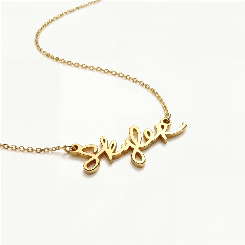 Close-up angled shot of the Clairmont handwriting necklace, highlighting the dimensional quality and craftsmanship of the solid gold personalized handwriting nameplate.