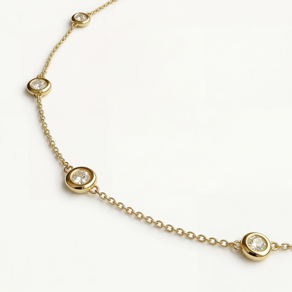 Close-up detail of the Luma necklace in yellow gold, highlighting the precise craftsmanship of the bezel-set diamonds and high-polish finish.