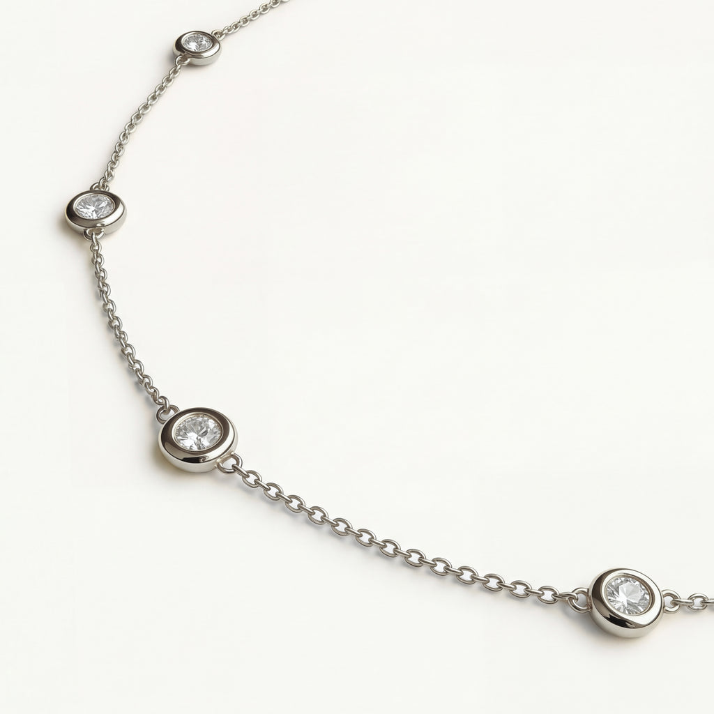 Detailed macro view of the Luma necklace in 14k white gold, showcasing the brilliance of the bezel-set diamonds on a solid gold chain.