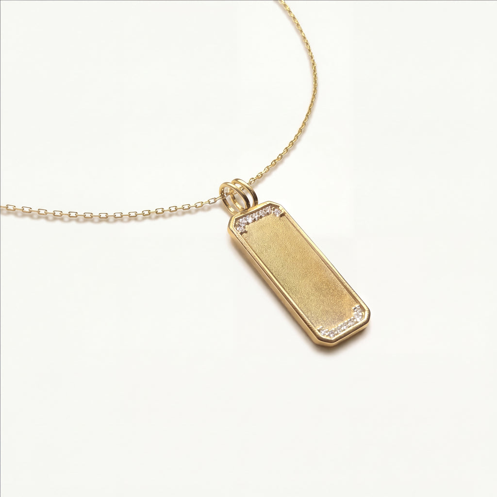 Detailed macro view of the Rosemere long pendant, showcasing the high-polish diamond-framed border against a sandblast textured solid gold center.
